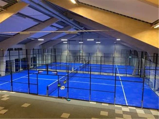 Inomhus sporthall med en pool och nät för racketsporter, på Lundegård Camping & Stugby.