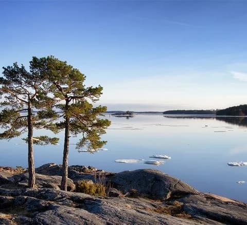 Vy över Gålö havsbad med öppet hav och klippig kustlinje.