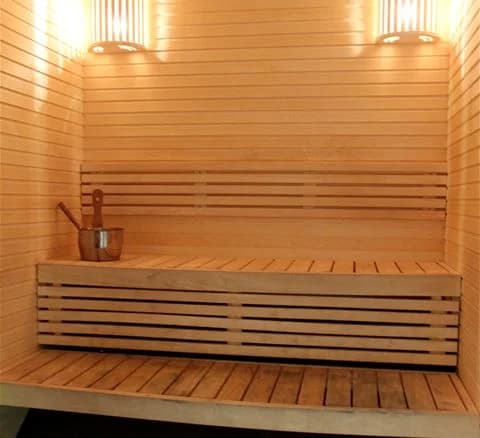 Bild av en träinredd bastu med träplankor på golvet och väggarna vid Gålö havsbad.