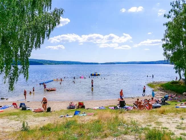 En somrig campingplats vid vattnet, med en kustlinje som inbjuder till rekreation och avkoppling vid stranden.