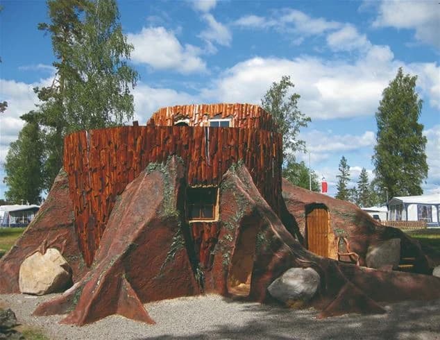 En bild av miljökonst och barrträd vid Karlsborgs camping, omgiven av naturskön skog.