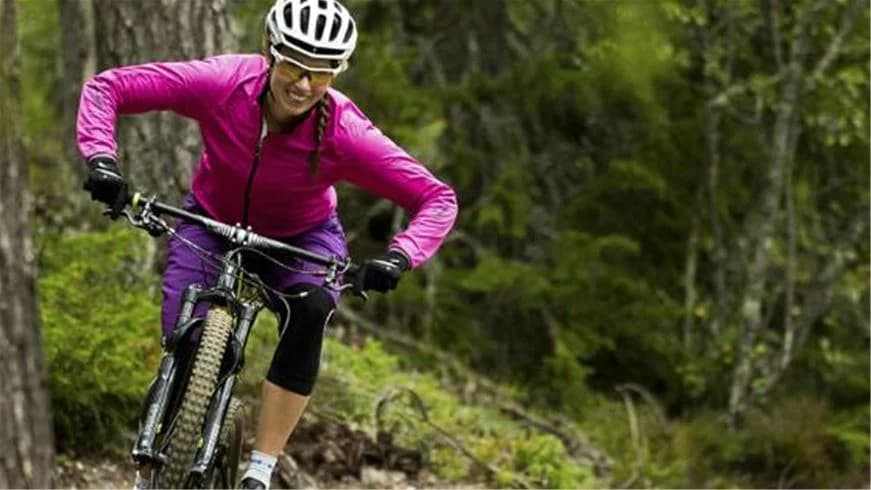 Cyklist med hjälm på cykel vid Idre fjäll camping, omgiven av friluftsmiljö.