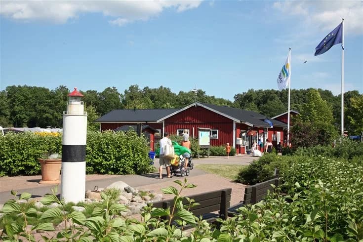 En grönskande campingplats i Saxnäs med gångvägar och områden för rekreation. Det är vår och träd och växter skapar skuggiga platser för besökare att njuta av sin semester.