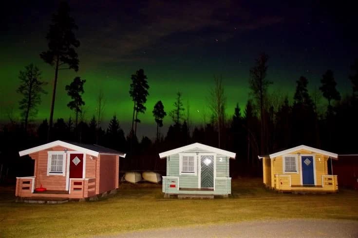 En mysig stuga omgiven av natur i skymningen vid Otterbergets Bad och Camping.