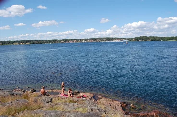 Bild av Tättö havsbad & camping visar en somrig kustlinje med havsvatten som breder ut sig mot horisonten. Perfekt för rekreation längs kusten.