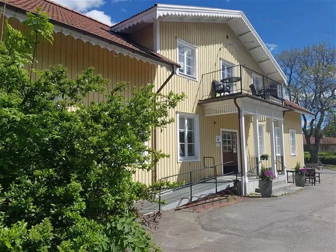 Bild av en rofylld bostadsområde vid Täntö Havsbad & Camping med pittoreska stugor och välskötta trädgårdar.