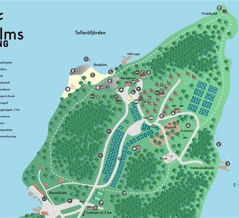 En naturskön park vid Waxholms camping, omgiven av grönska och träd, med stigar för promenader.