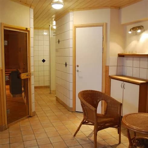 Interiör av en rymlig och väl upplyst lokal med trägolv och träpaneler på väggarna. Taket är utrustat med moderna VVS-armaturer.