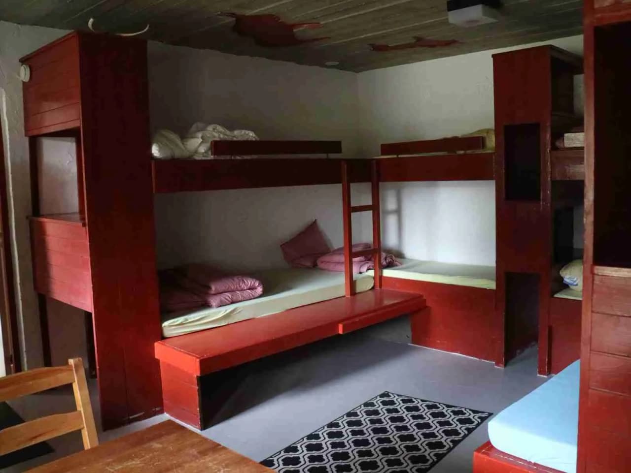 En interiörbild av ett sovrum på Grottbyns camping visar träinspirerad inredning med våningssängar och trägolv.