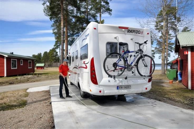 En cykel parkerad vid Camp Viking, med synliga detaljer som ram, hjul, däck och styre, mot en bakgrund av ett rekreationsområde.
