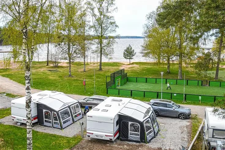 Bild av en campingplats på Ursand Resort & Camping, med uppställda husvagnar och husbilar på en parkeringsplats.