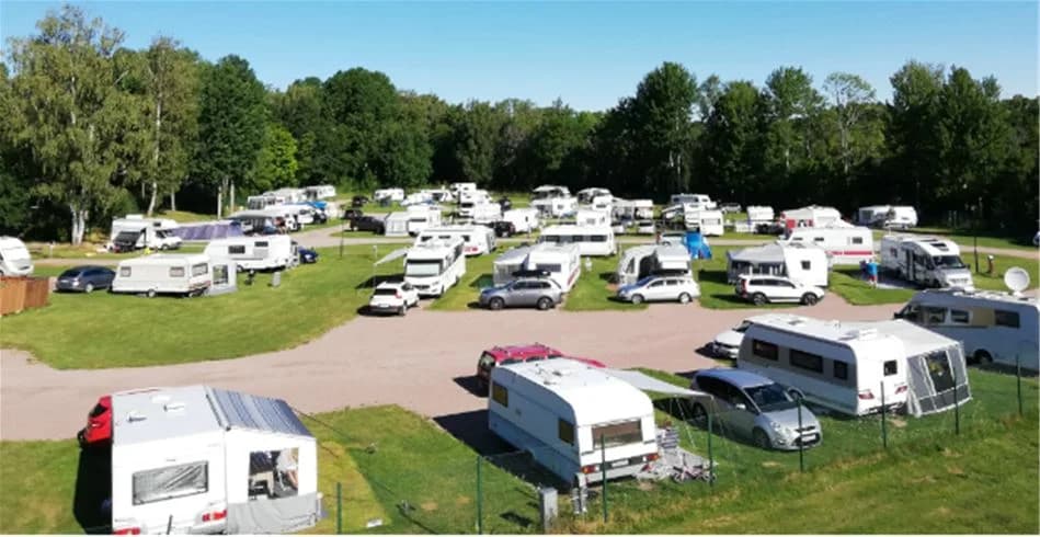Flygbild över Skantzö Bad & Camping som visar husbilar och husvagnar parkerade på campingområdet, omgivna av grönska.