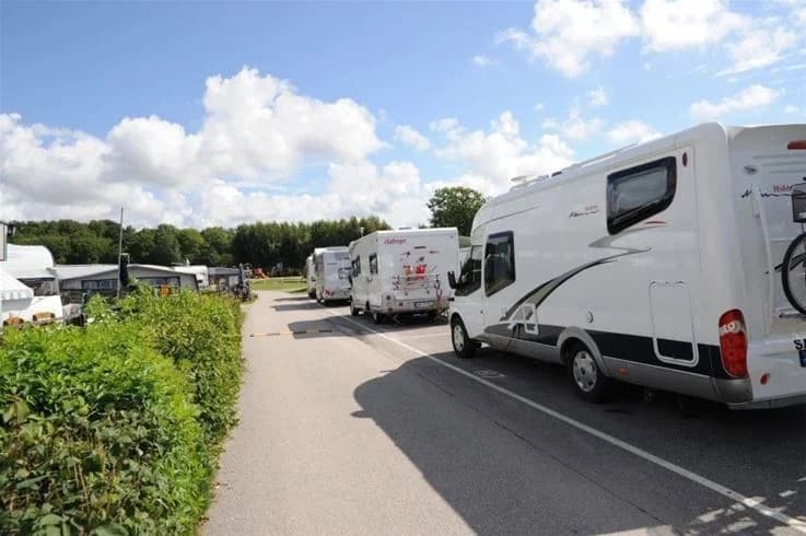 En campingplats vid Grebbestadfjorden med flera husbilar och husvagnar parkerade.