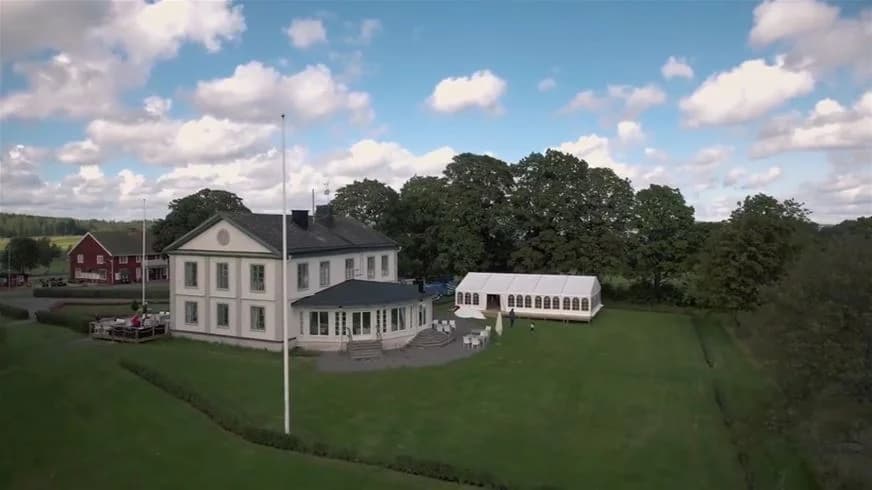 Bild av Degernäs camping som visar en grönskande gräsmatta och flera pittoreska stugor. Campingen omges av vacker natur, vilket ger en inbjudande och lantlig atmosfär.