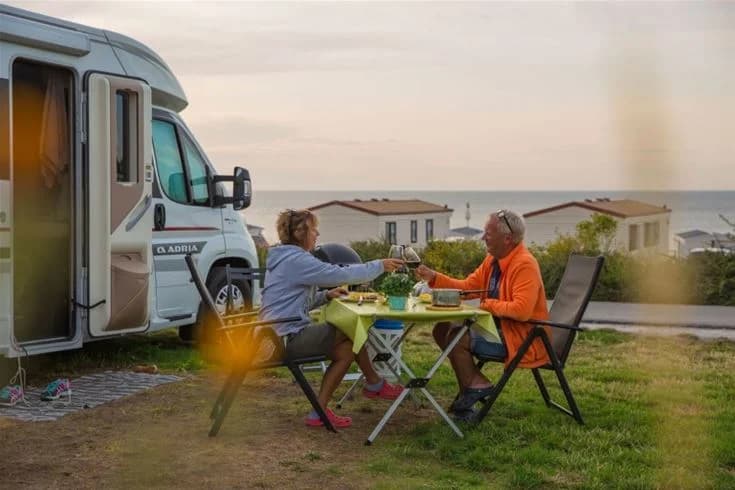 Bild av Kneippbyn Resort Visby med campingstolar och ett utomhusbord uppställda för rekreation och avkoppling. Området tycks vara välkomnande för semesterfirare och andas fritid och nöje.