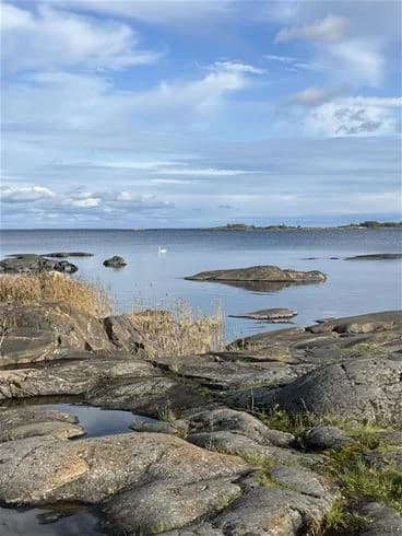 En vy över ängskärs havscamping med blått hav, klippiga kuster och steniga stränder i förgrunden.