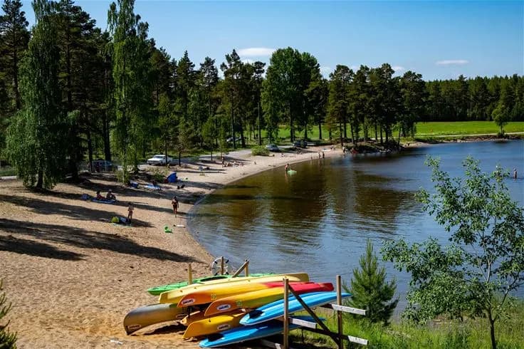 Vy över en naturskön sjö med klart vatten och omgivande skogar, typiskt för landskapet vid Norra Dellen Familjecamping.