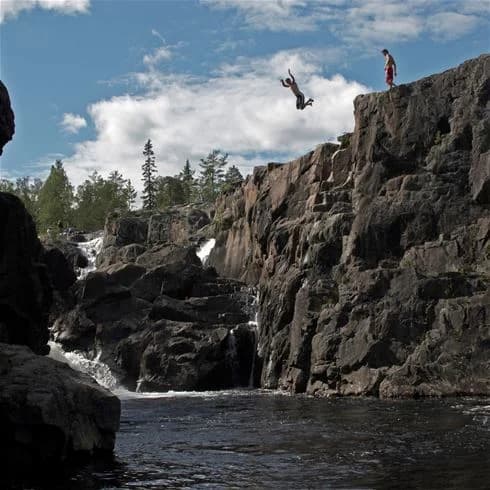Vy över Storforsens brusande vatten, omgiven av stora klippformationer och natursköna omgivningar.