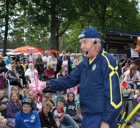 En grupp människor klädda i jeans och hattar njuter av fritidsaktiviteter tillsammans vid Ystad Camping, med en avslappnad och glad atmosfär.