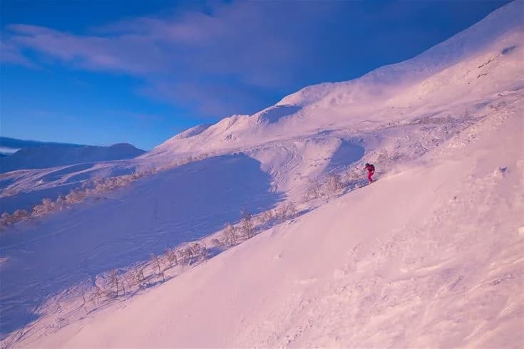 En snötäckt bergslandskap med bergstoppar och en glaciär i bakgrunden, typiskt för vintertid vid Camp Kittelfjäll.