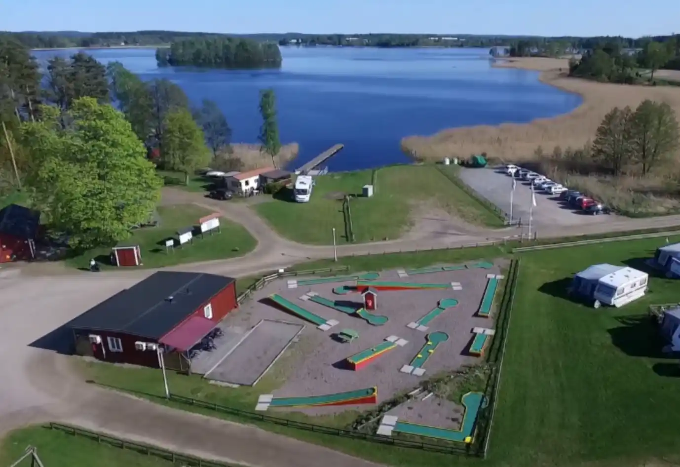 Flygfotografi av Husabergsudde camping, som visar en parkmiljö med flera uppställda tält.