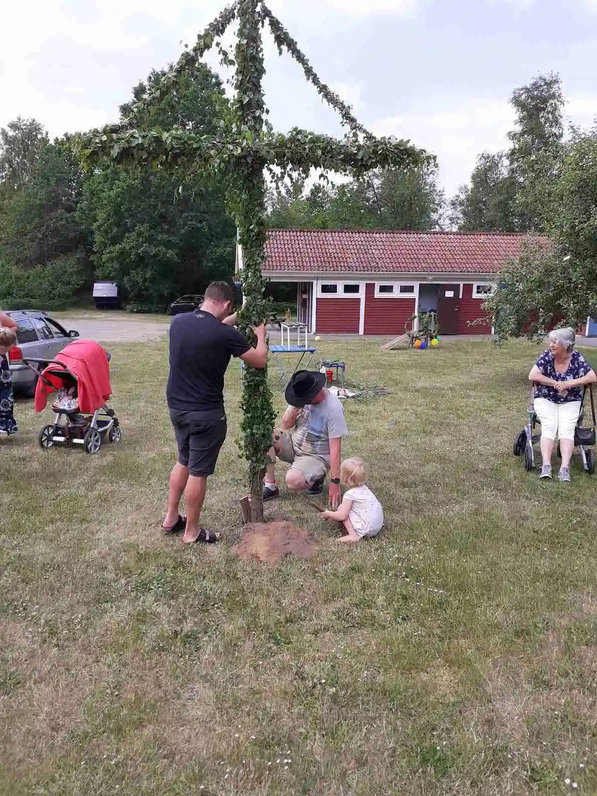 Ett barn leker i en park på Linneryds camping, glädjefyllt balanserande på en lekstruktur.