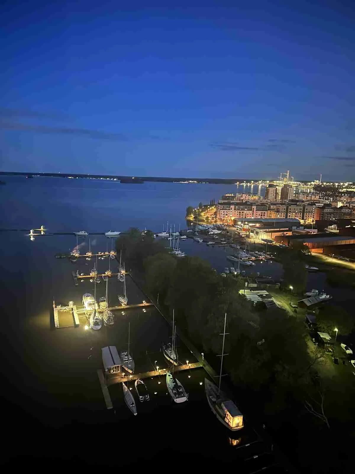 En kvällsvy vid Waxholms Camping med båtar vid kajen, speglingar i vattnet och en stilla hamnatmosfär.