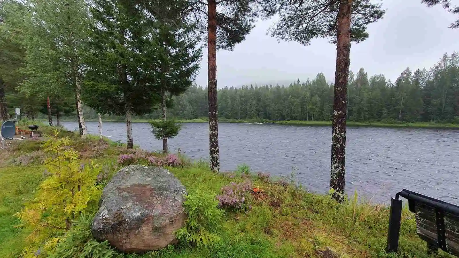 En naturskön vy vid Stöten Camping med en vattenspegel omgiven av frodig grönska och träd, vilket skapar en lugn och fridfull atmosfär i en naturlig miljö.