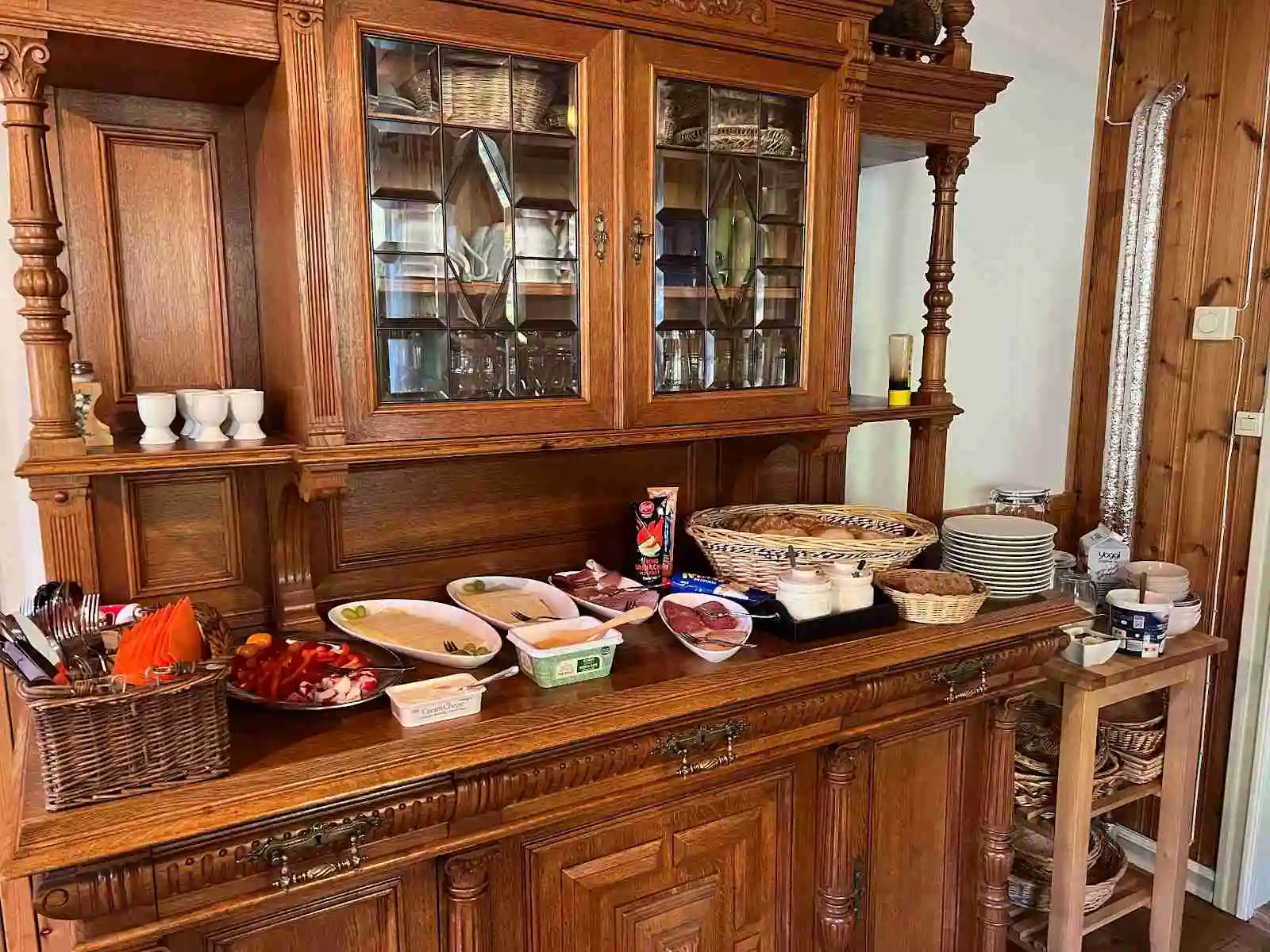 En varm och inbjudande inomhusmiljö med trähyllor fyllda med prydnadssaker och porslin, vilket ger platsen en hemtrevlig och rustik känsla.