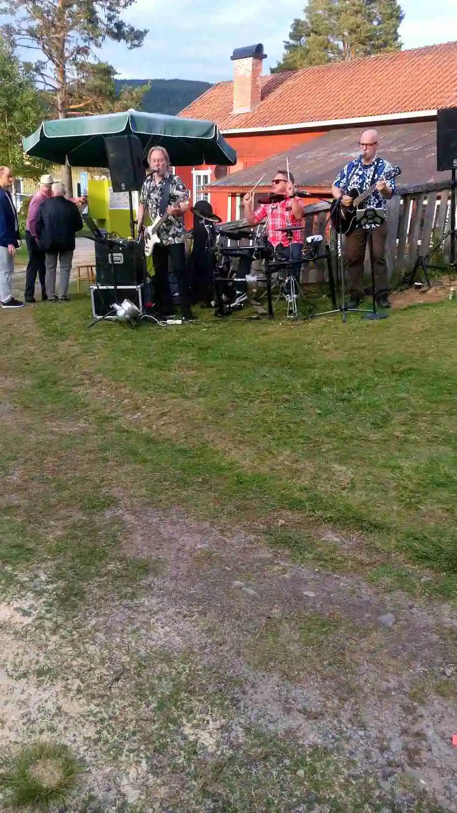 En grön gräsmatta med stolar i ett rekreationsområde på Höljes Camping, en plats för fritidsaktiviteter och avkoppling.