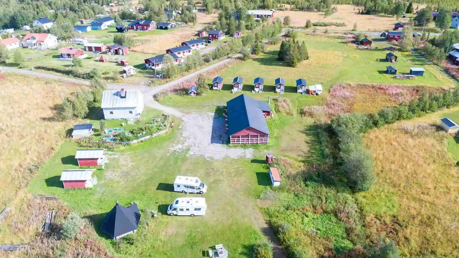 Flygbild av Piilijärvi camping som visar en lantlig plats med stugor och öppet landskap.