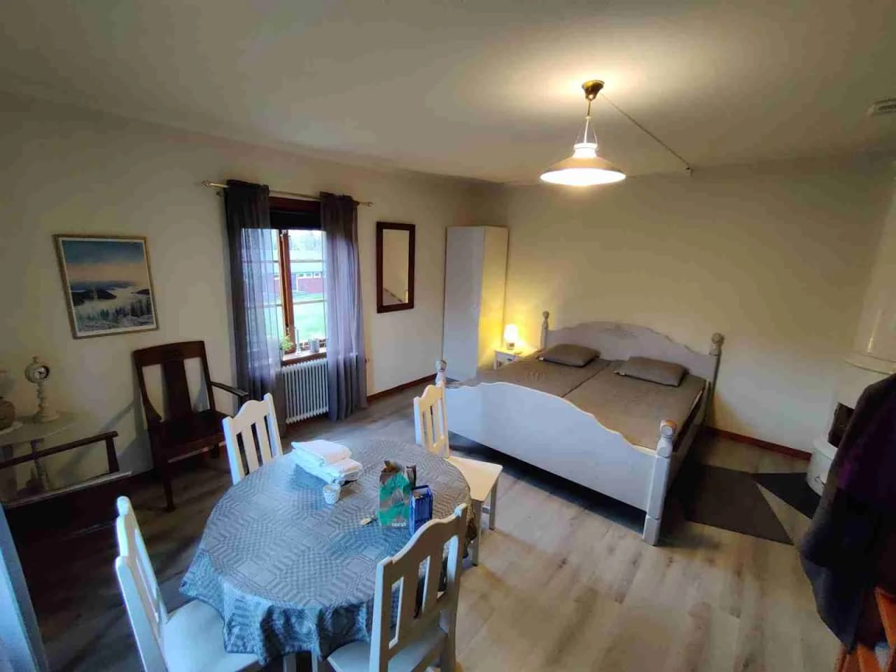 En rymlig interiör i Kustladan med trädetaljer, som visar ett golv av trägolv, trämöbler inklusive bord och stolar, omgivna av en ljus och luftig atmosfär.