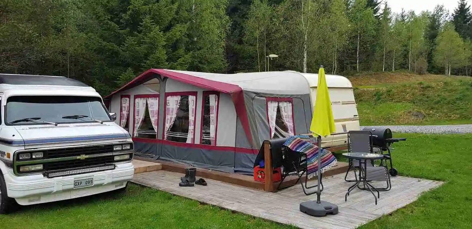 En campingplats i Sandviken med uppställda husbilar, tält och områden med presenningar.