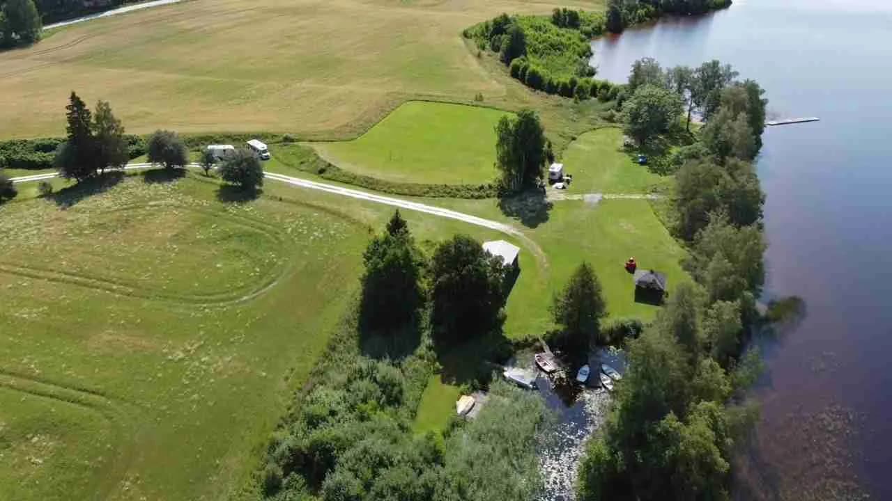 Fågelskådning över Vreten kursgård med vidsträckt naturlandskap, öppna fält och slingrande vattendrag.