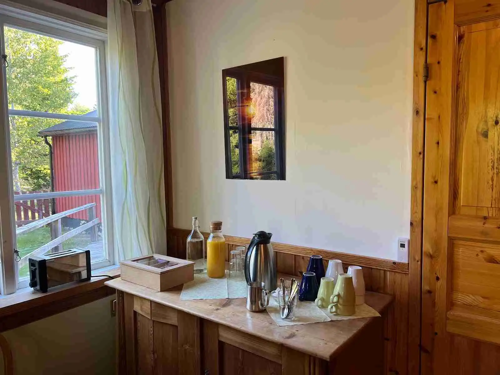 En mysig interiör med trägolv och träinredning på Nya Skogsgården Camping & Vandrarhem. Rummet är varmt upplyst och har möbler i trä som skapar en inbjudande atmosfär.