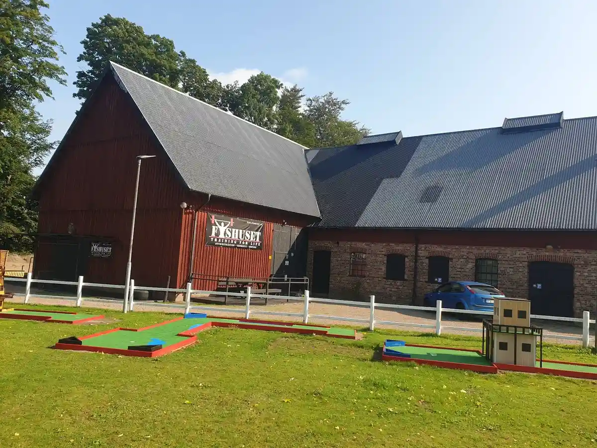 En skuggig campingplats med ett barn som leker i närheten av Elfdalens camping.