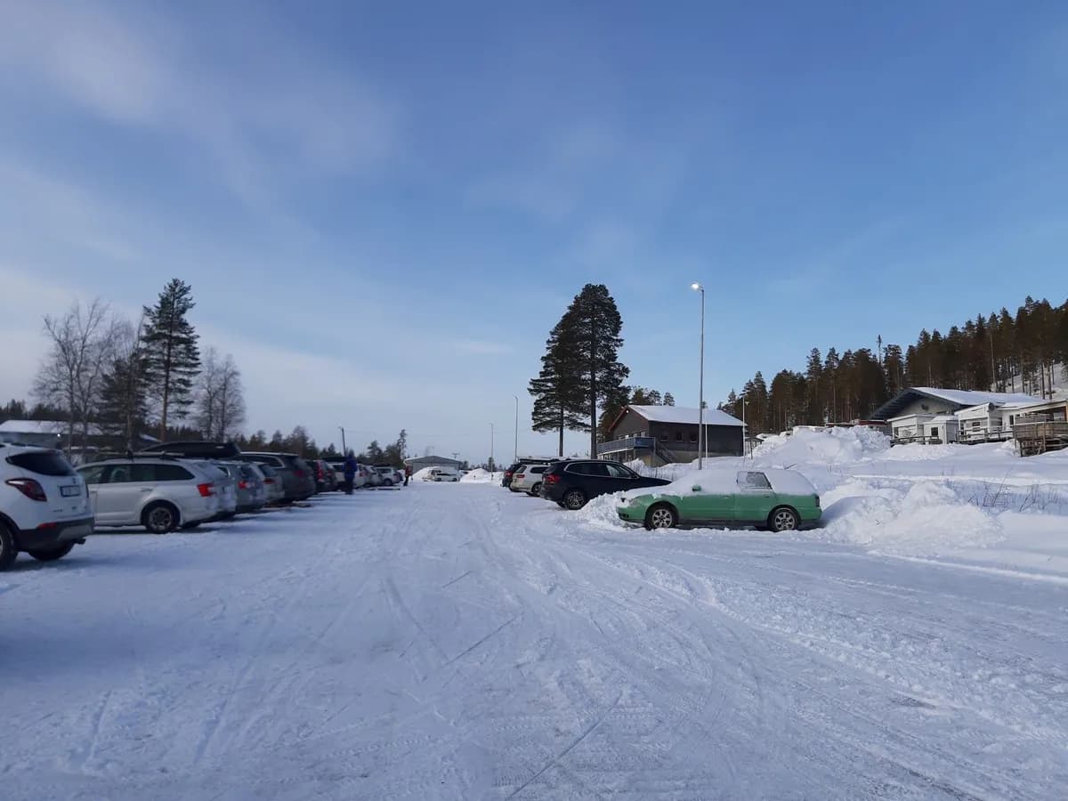 En bil parkerad i ett snöigt vinterlandskap vid Storklinta Skidcenter AB.