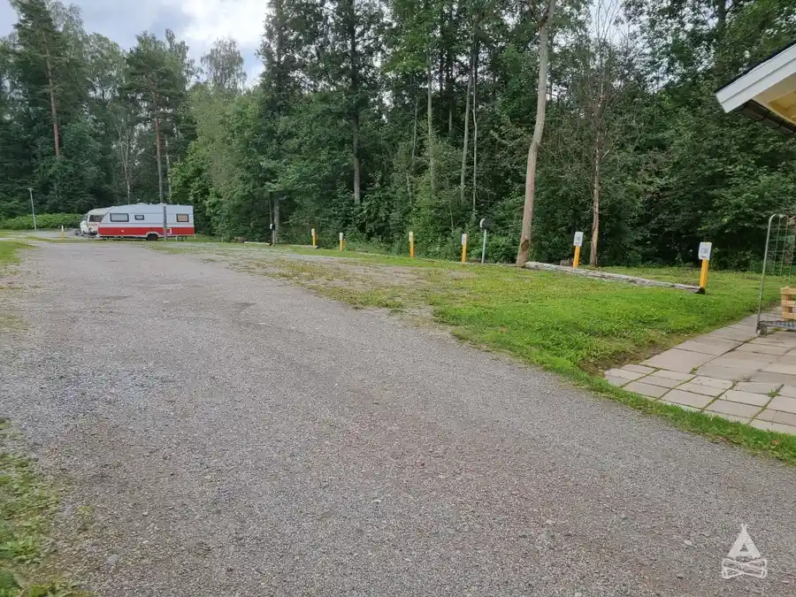 En asfalterad väg kantad av träd och grönska vid Sofielund vandrarhem & camping.