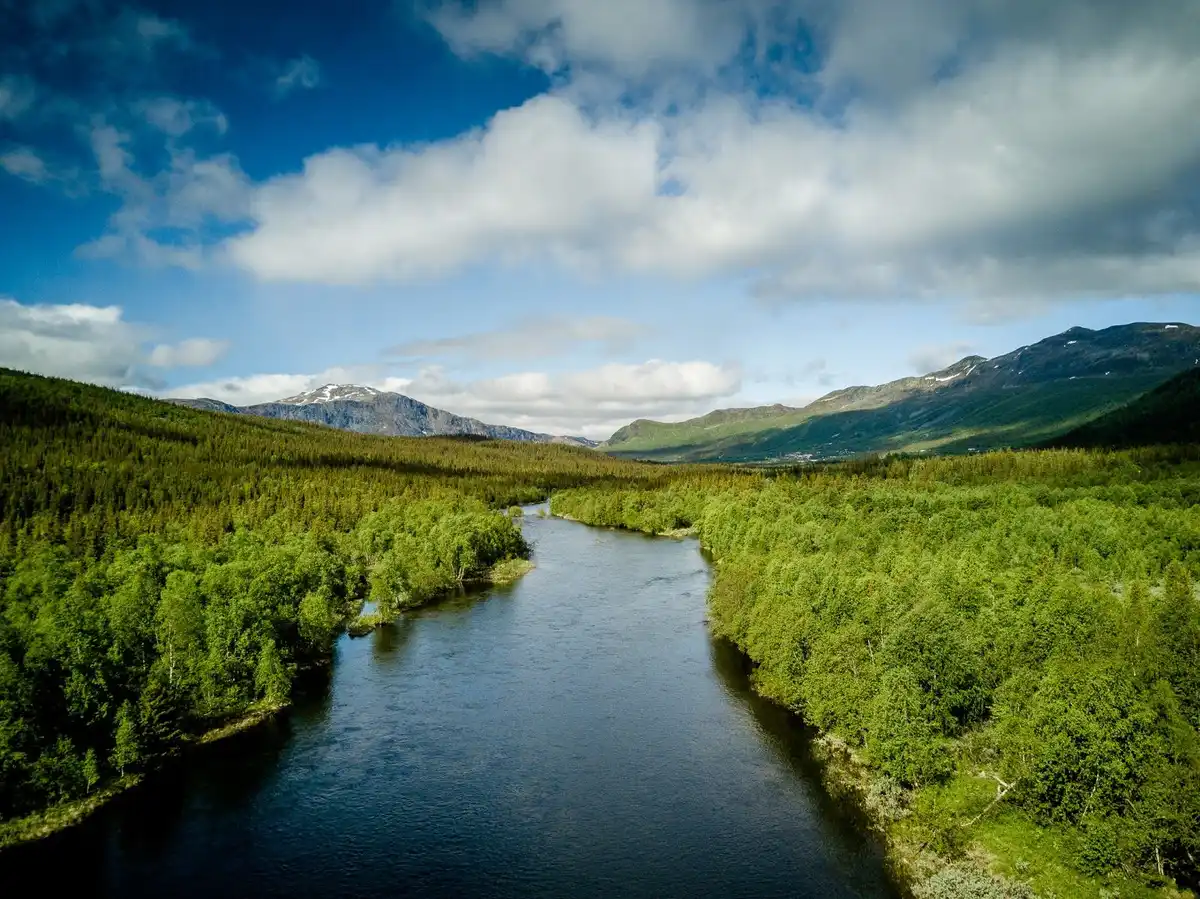 En storslagen fjällmiljö med berg och dalar omgivna av vattendrag, som bjuder på orörd natur och friluftsäventyr i Kittelfjäll.