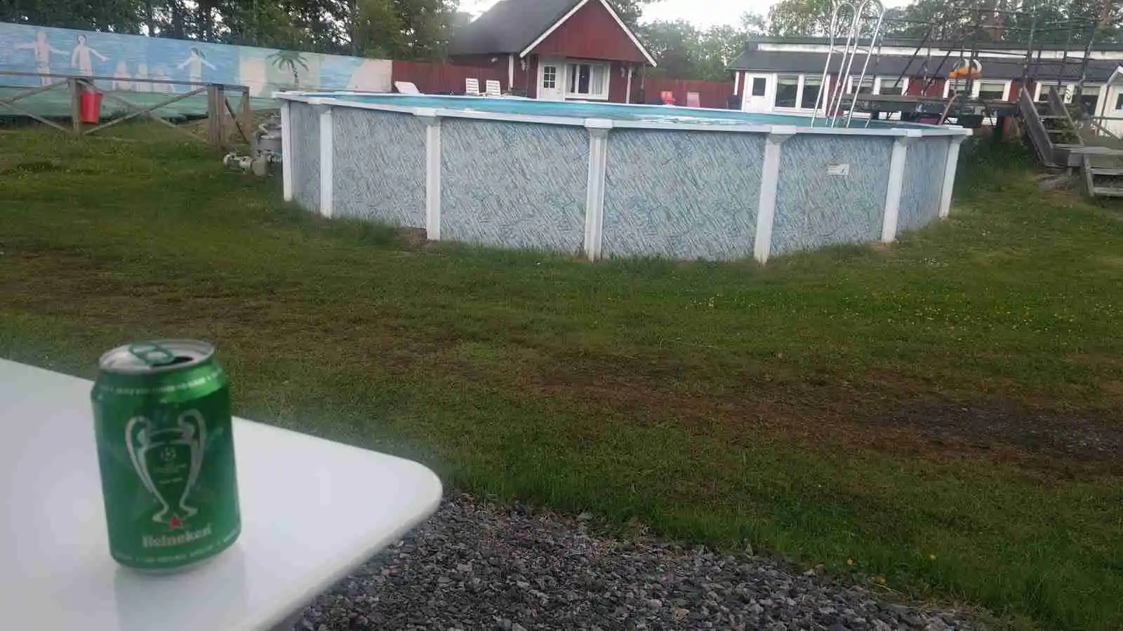 En grönskande bakgård med en glittrande swimmingpool, idealisk för avkoppling och familjeaktiviteter på Arkösunds camping.
