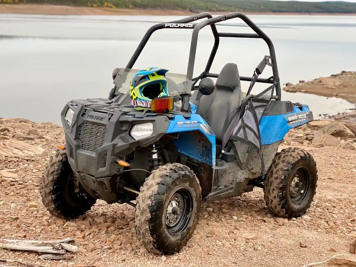 En fyrhjulsdriven terrängfordon på offroadcamp, omgiven av grov terräng och däckspår, redo för ett äventyr utanför vägarna.