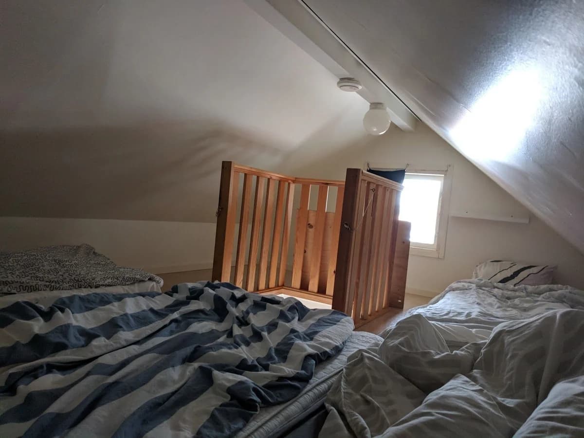 Alt-text: Ett interiörfoto från Ramsvik Stugby & Camping visar ett sovrum med träinredning. Rummet har ett tak av trä, ett golv av trä och är inrett med en säng och belysning som skapar en mysig atmosfär.